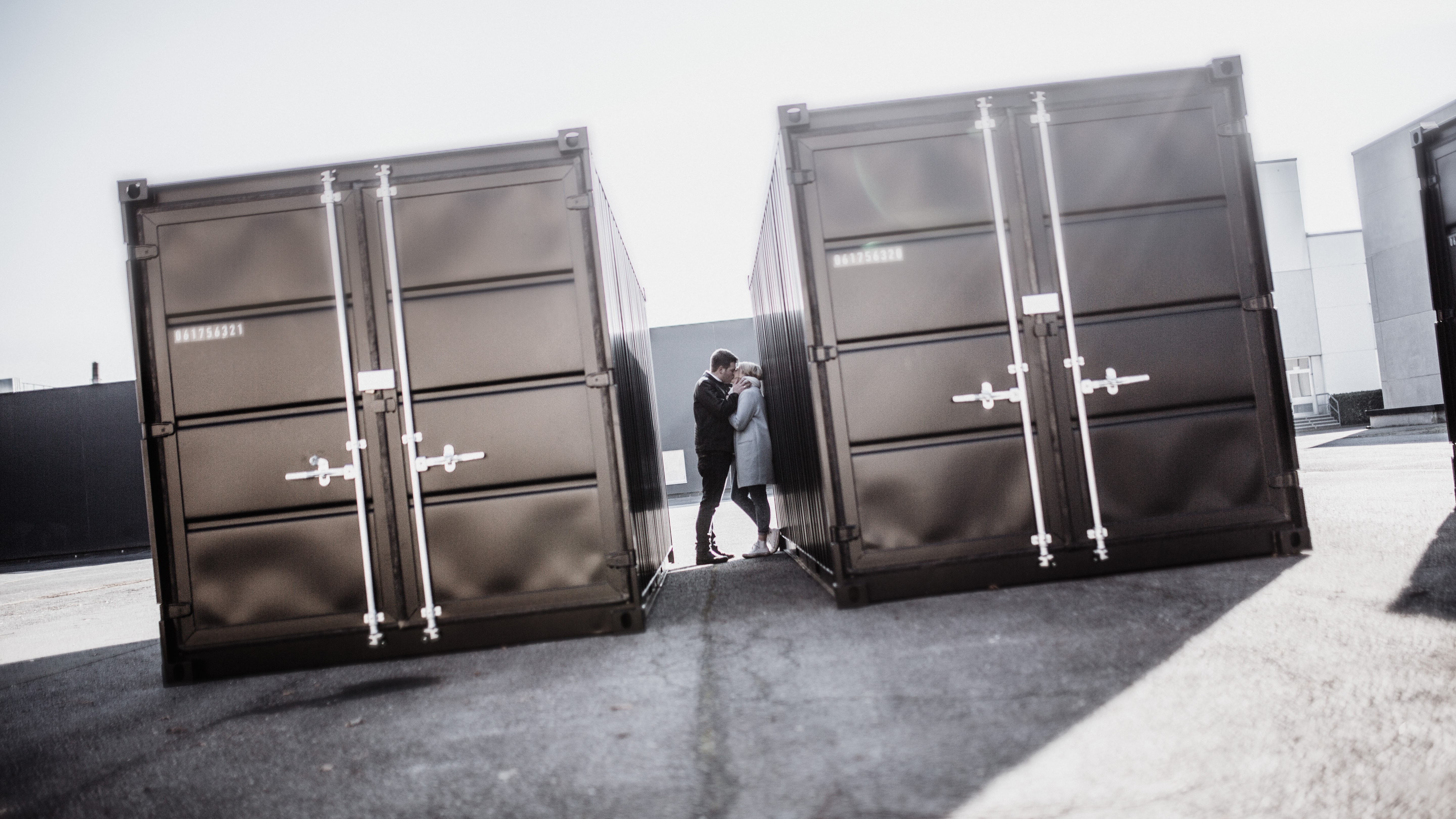 Paar küsst sich zwischen zwei Containern